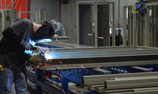 Welder welding a hollow metal frame